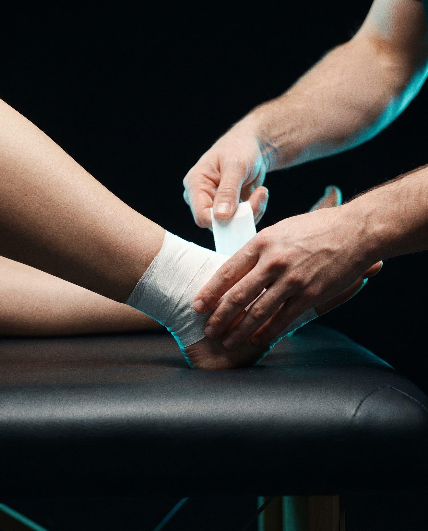 Athletic tape being wrapped around an ankle
